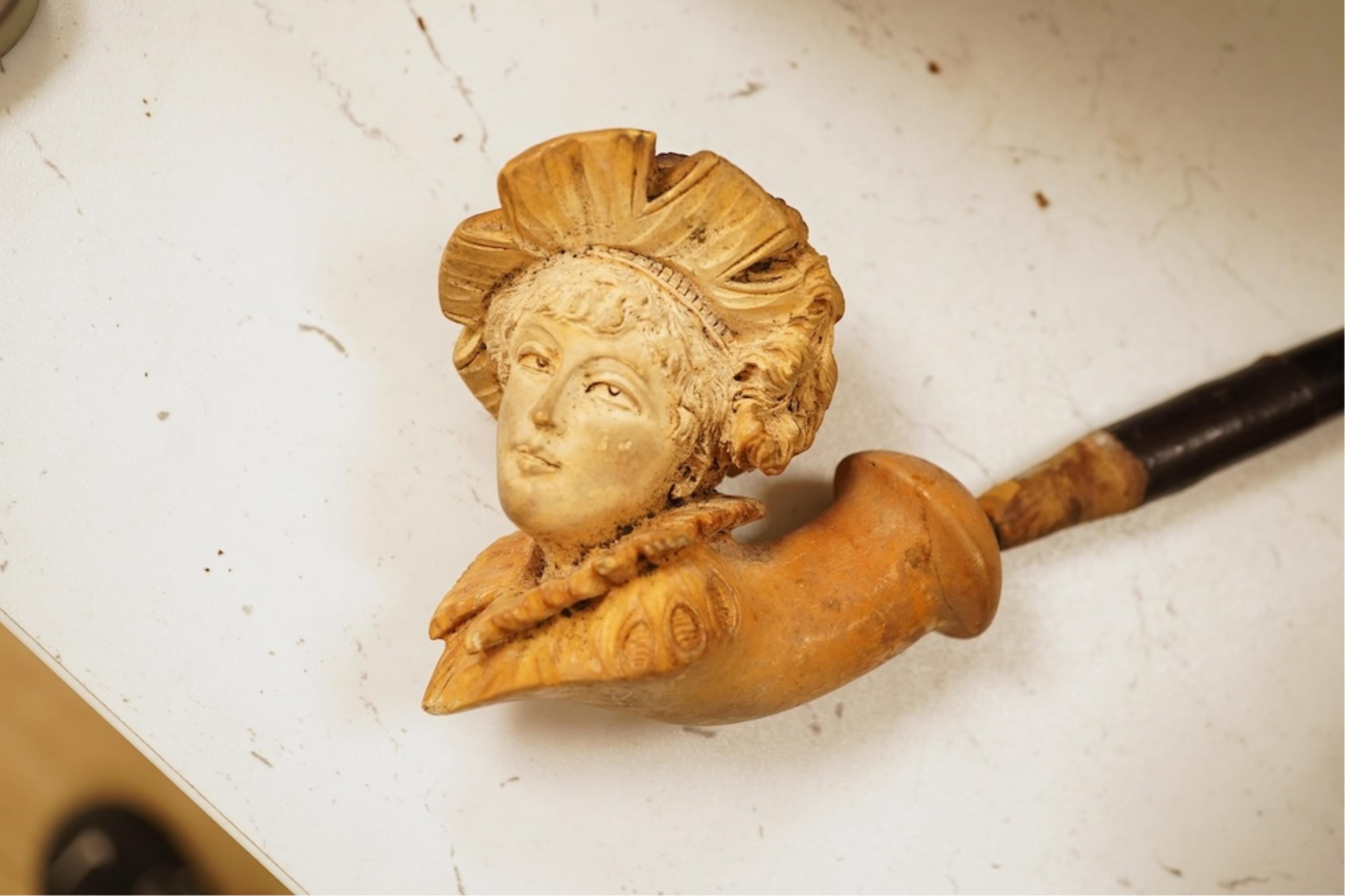 A 19th century German cold-painted terracotta bust, on ebonised socle and a Meerschaum pipe in case, bust 27cm high